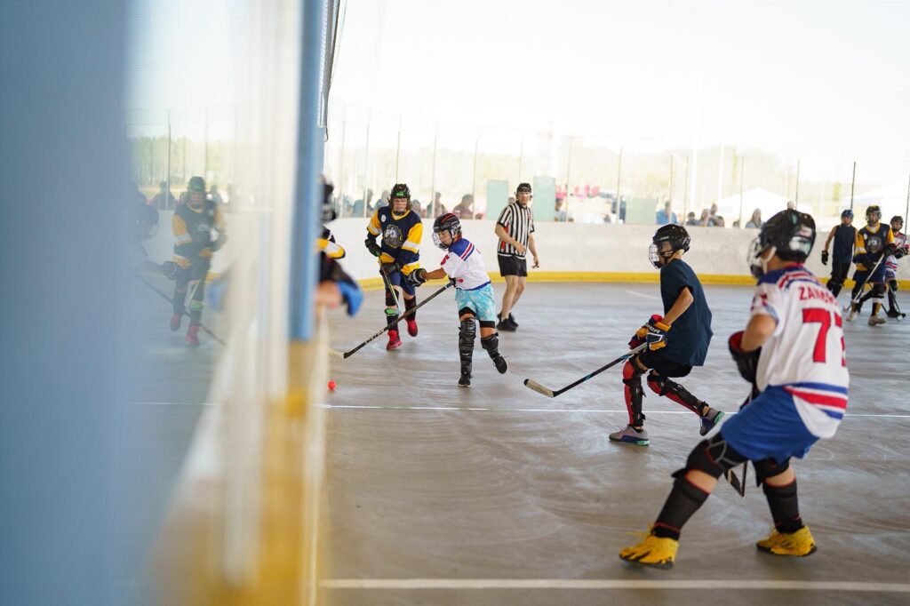 Youth players competing in outdoor open ball hockey game
