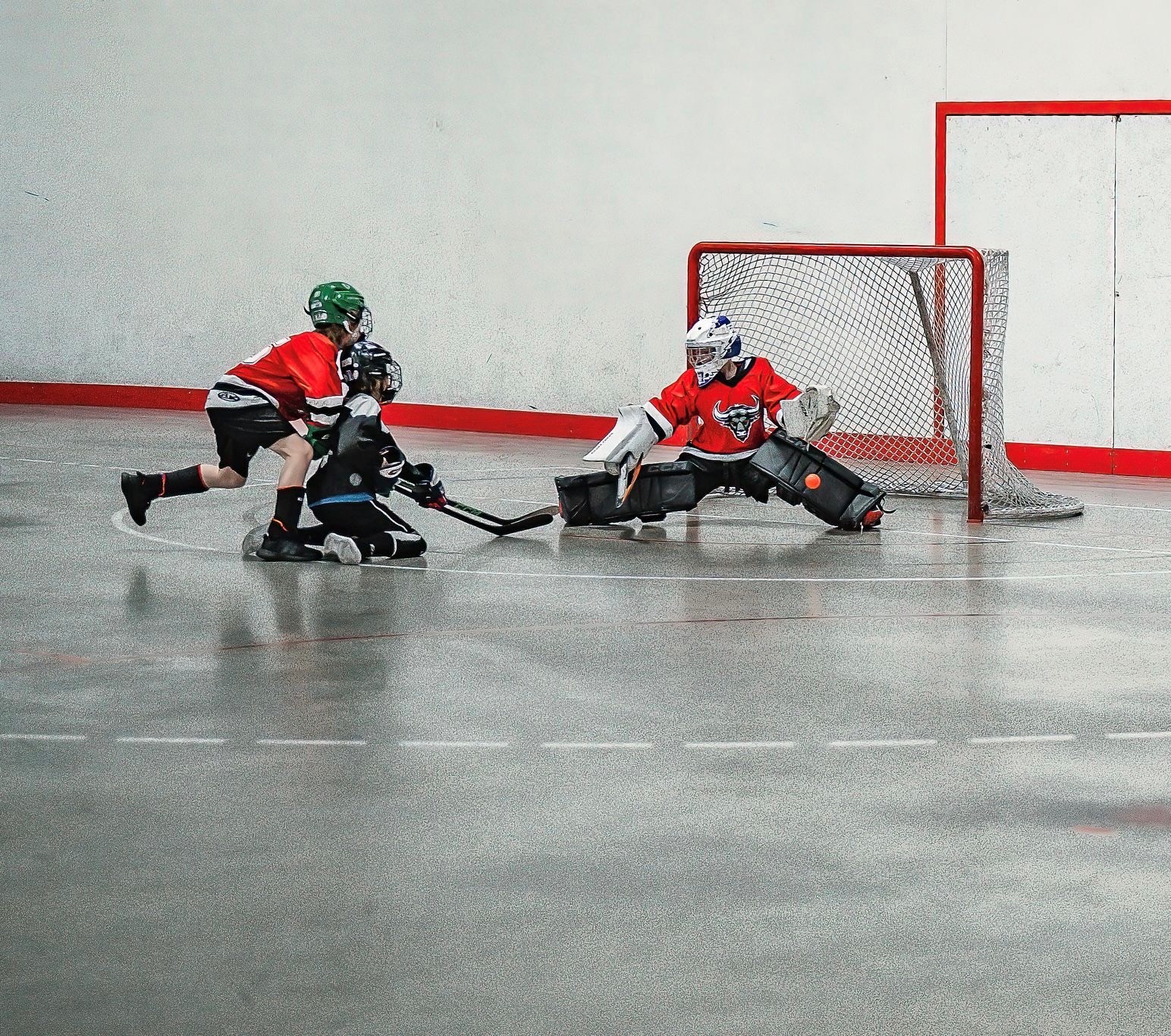 BHPE Mavericks goalie Lincoln Cary drops low to make a save during a ball hockey game.